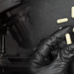 Flacon de compléments alimentaires NAD+ DIX avec gélules et un microscope en arrière-plan.