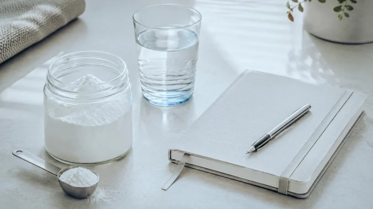 Créatine et sécurité : pot, verre d'eau et carnet pour examiner ce que disent les études