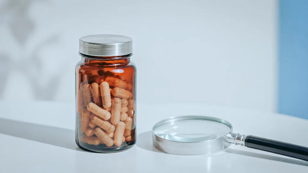 Purity check of a jar of Tribulus terrestris capsules examined under a magnifying glass