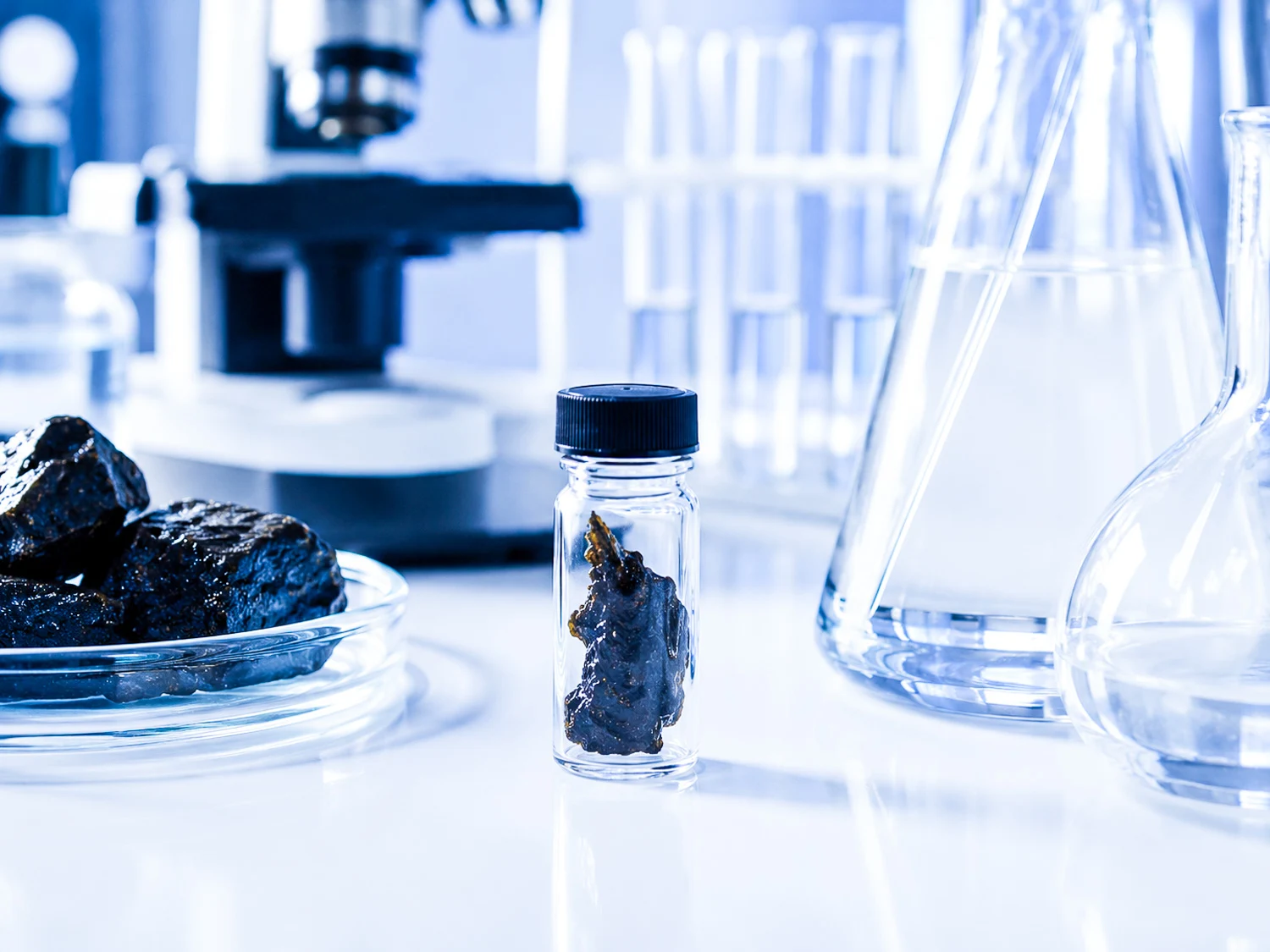 Flacon de shilajit sur un plan de travail, près de matériel de laboratoire.