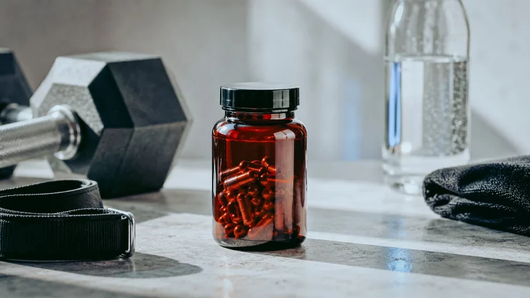 Complément Tribulus terrestris posé près d'un haltère, musculation et vitalité